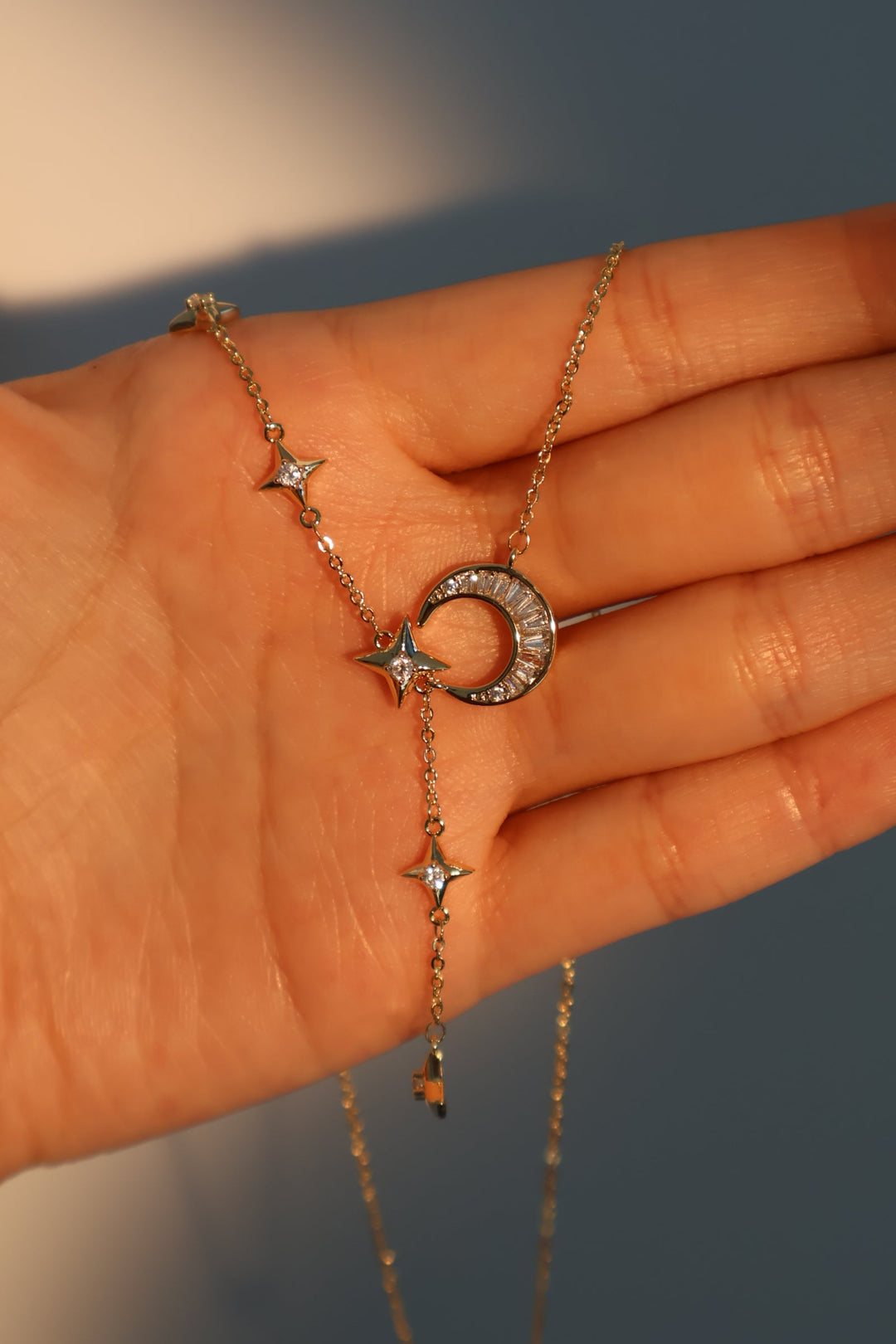 Collana pendente con stella e luna di diamanti