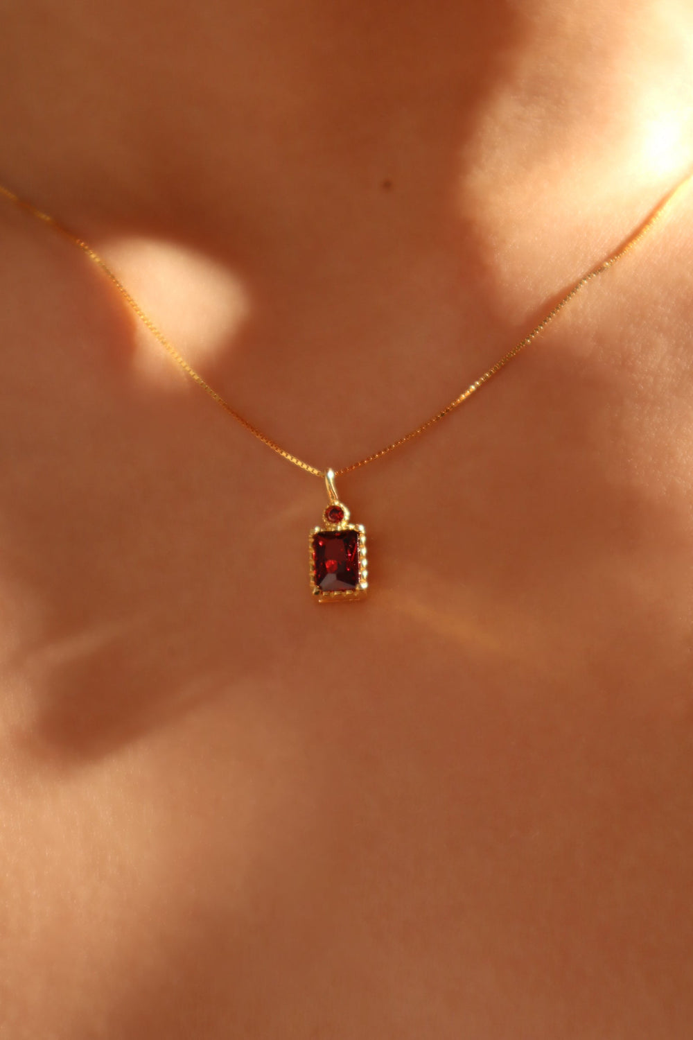 Collana con ciondolo con gemma rossa