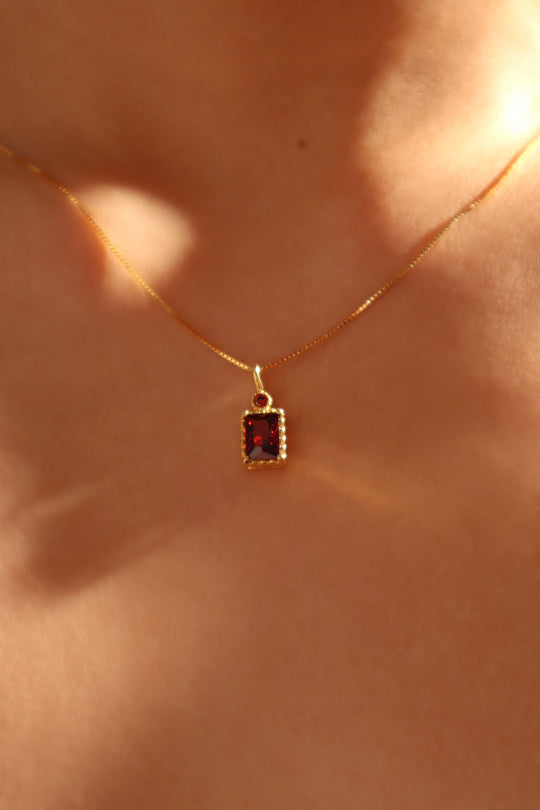 Collana con ciondolo con gemma rossa